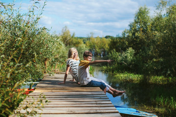 mother and son sitting on a wooden pier