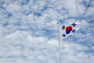 푸른하늘을 배경으로 태극기가 바람에 휘날리고 있다