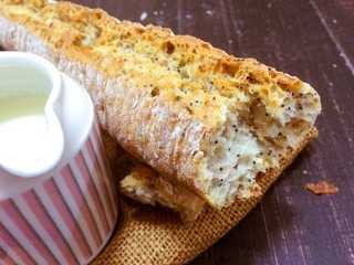 Свежий хлеб на материале из льна и деревянном столе. Кувшин с молоком.