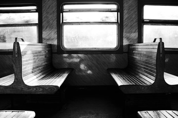 Couple of benches in train. Travel in transport. Backlight. Black and white photo