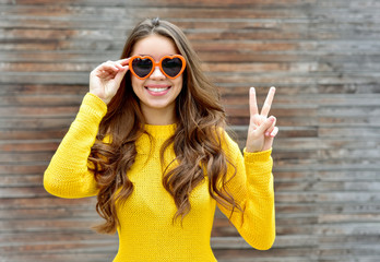 Beautiful smiling brunette woman in sunglasses over wooden backg