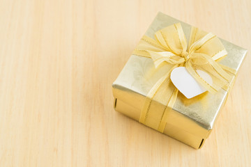 Gold gift box on wooden background