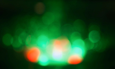 abstract green, orange bokeh circles on black background