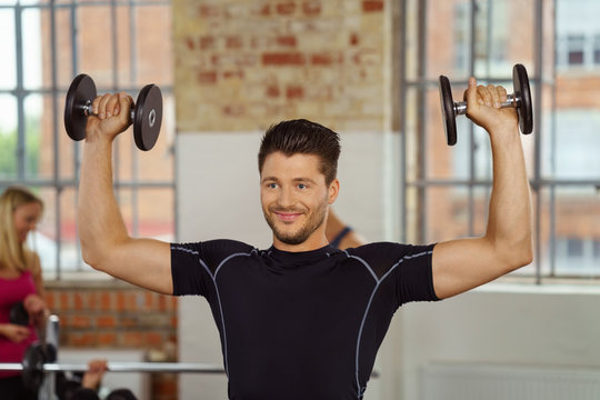 mann trainiert mit kurzhanteln im sportstudio