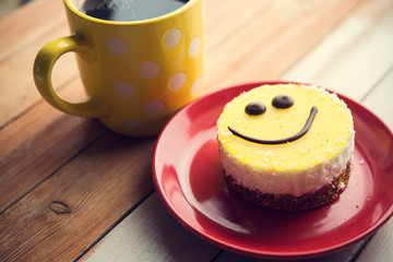 Coffee red cup and smile cake on wood table
