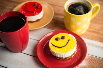Coffee red cup and smile cake on wood table