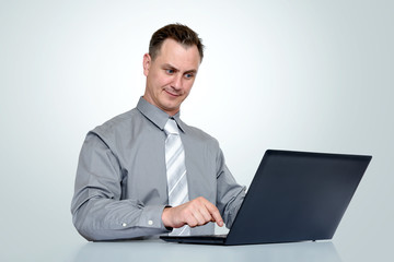 Office man in shirt and tie with laptop on background