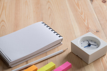 Office desk table with Notebook,clock and supplies