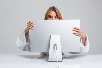 Naklejka premium young woman sitting in the table and using computer