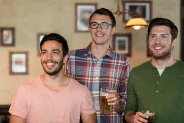 happy male friends drinking beer at bar or pub