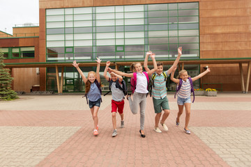 group of happy elementary school students running