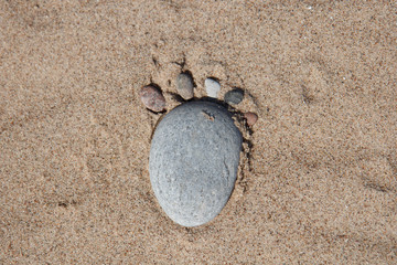 Fototapeta na wymiar Rock footstep in sand