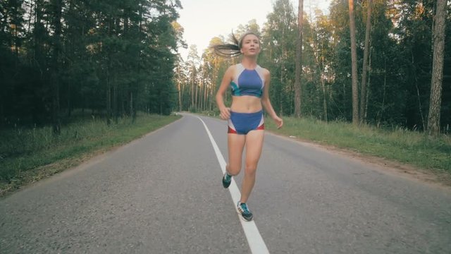 Athletic youg woman Jogging in a park. Stedycam shot. HD.
