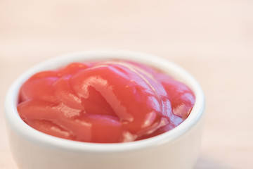 bowl of ketchup or tomato sauce on wooden table