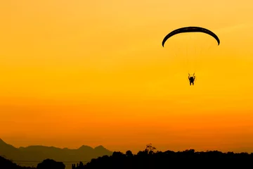 Photo sur Plexiglas Sports aériens Glider, Paramotor flying with orange twilight sky