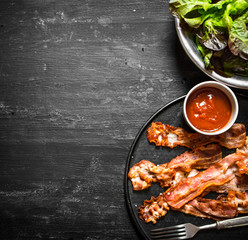 Fried bacon with sauce and greens.