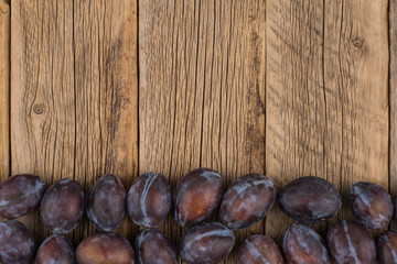 plums on a wooden background.