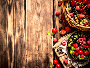 Fototapeta na wymiar Fresh berries in an old basket. On wooden table.