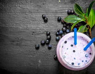 Blueberry smoothies. On black wooden background.