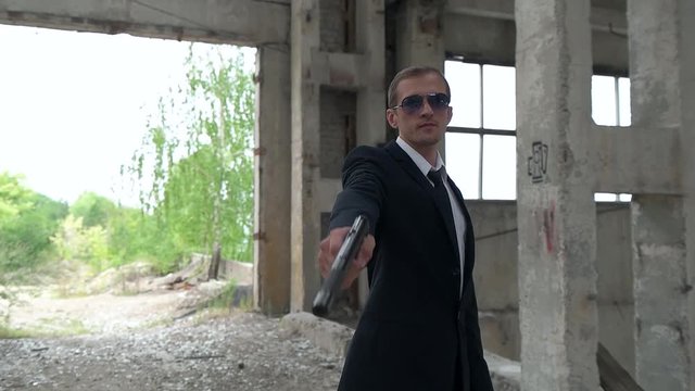 killer shoots a gun with a silencer