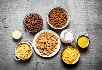 Cereal and a jug of milk. On stone table.