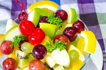 Bowl of healthy fresh fruit salad on pattern of Thai hand made fabric background