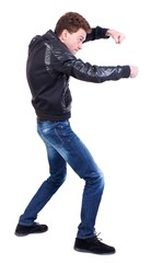 Naklejka premium back view of guy funny fights waving his arms and legs. Curly guy in a black leather jacket funny fights