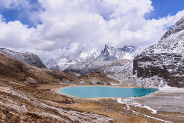 Milk lake on the snow mountains with clouds and sky in Yading, China.
