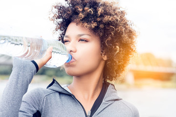 Girl drinking water from bottle.