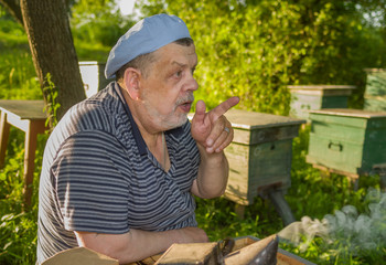 Outdoor portrait of speaking elderly man - bee-keeper