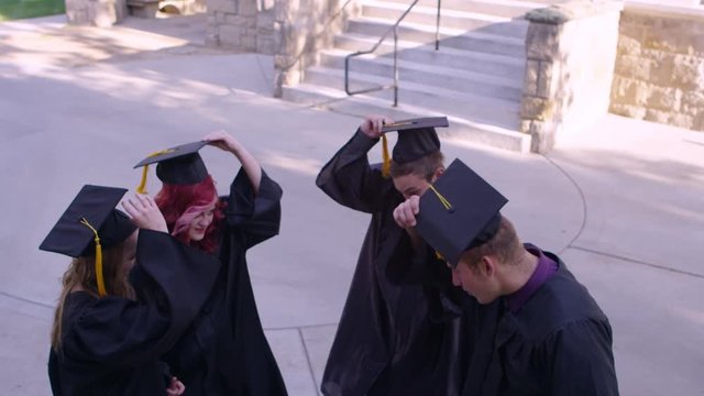 Graduating friends throwing caps in the air