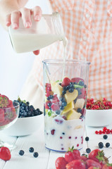Close up of a young woman prepare to blending fruits