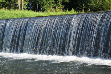 water falling down from the weir on the river