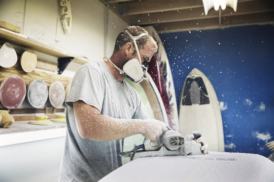 Man making a surfboard at workshop
