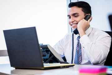 Salesman in office making phone call