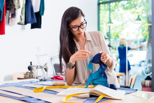 Asian Fashion Designer Woman Sewing In Her Workshop