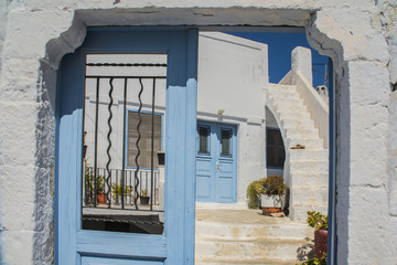 old blue rough the door of the beautiful white village street Greece