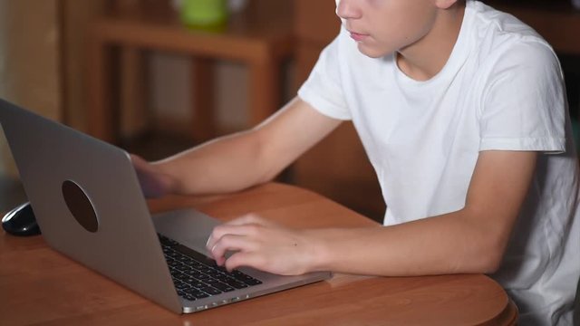 Teen boy working on laptop