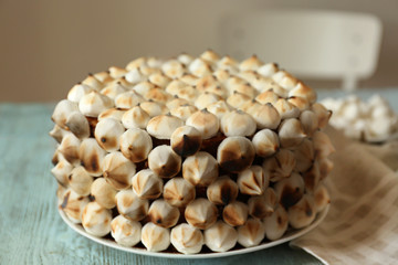 Delicious cake with marshmallow and biscuit on wooden table