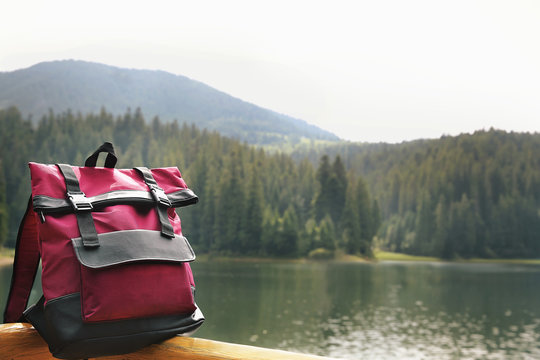 Fototapeta Red backpack on mountain lake background