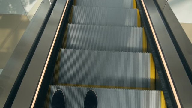 The photo with legs on escalator top view