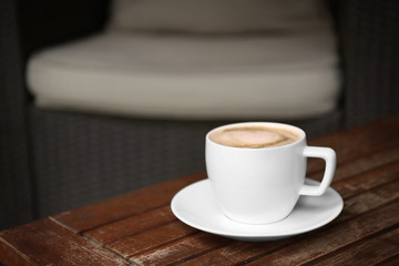 Cup of fresh coffee on wooden table