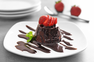Chocolate fondant cake with fresh strawberries on the plate