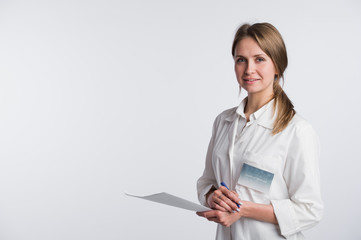 Beautiful nurse smiling and taking notes on a white isolated background