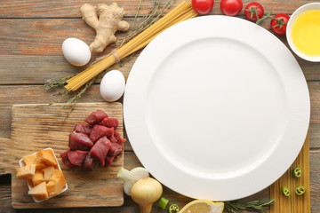 Empty plate with ingredients for dinner on table
