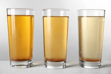 Glasses with dirty water on light background