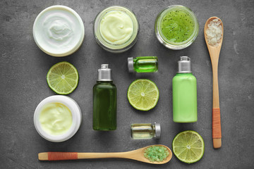 Hygienic cosmetic products and sliced lime on grey textured background