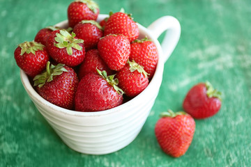 Fresh strawberries in cup on table