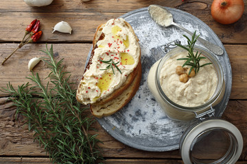 ceci humus o crema di ceci in barattolo di vetro sfondo tavolo rustico di legno