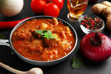 Tasty chicken curry in pan and spices, closeup